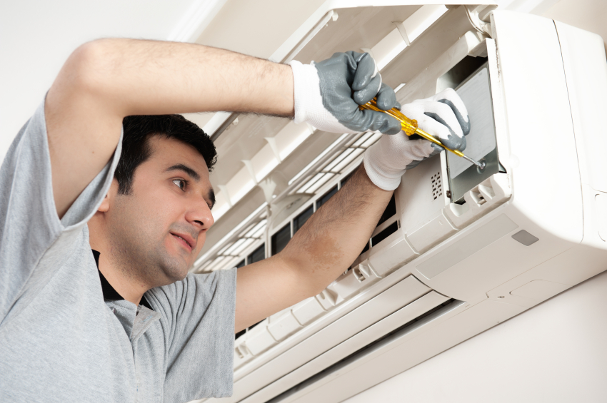 man fixing the indoor unit of a split type air conditioner